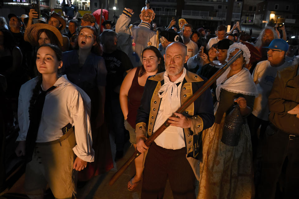 People in period costume watch a burning effigy of Benedict Arnold during the annual Burning of Benedict Arnold Festival, Saturday, Sept. 9, 2023, in New London, Conn. The burning of Arnold marks the anniversary of the day in September 1781 that the Connecticut native led British troops into the city and burned most of it to the ground. (AP Photo/Jessica Hill)