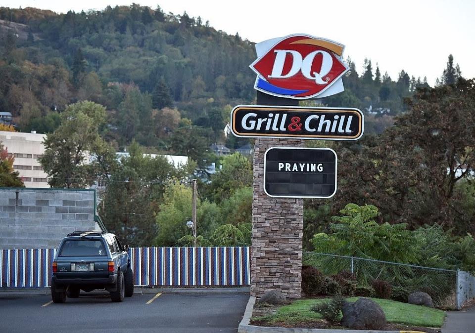 A Dairy Queen restaurant with a sign that says &quot;praying&quot;
