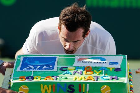 Mar 31, 2015; Key Biscayne, FL, USA; Andy Murray pretends to take a bite of a cake presented to him after his 500th ATP win after defeating Kevin Anderson (not pictured) on day nine of the Miami Open at Crandon Park Tennis Center. Murray won 6-4, 3-6, 6-3. Mandatory Credit: Geoff Burke-USA TODAY