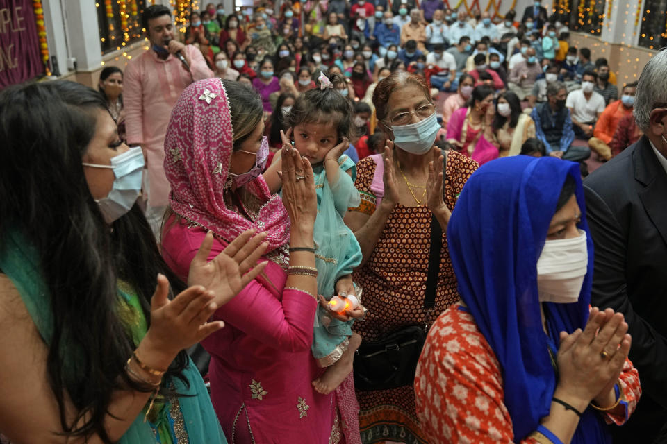 Hindu devotees pray at a temple during Diwali, the festival of lights, in Hong Kong, Thursday, Nov. 4, 2021. Millions of people across Asia are celebrating the Hindu festival of Diwali, which symbolizes new beginnings and the triumph of good over evil and light over darkness. (AP Photo/Kin Cheung)