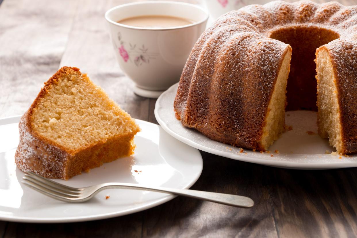 Slice of yogurt bundt cake served with a cup of coffee with milk