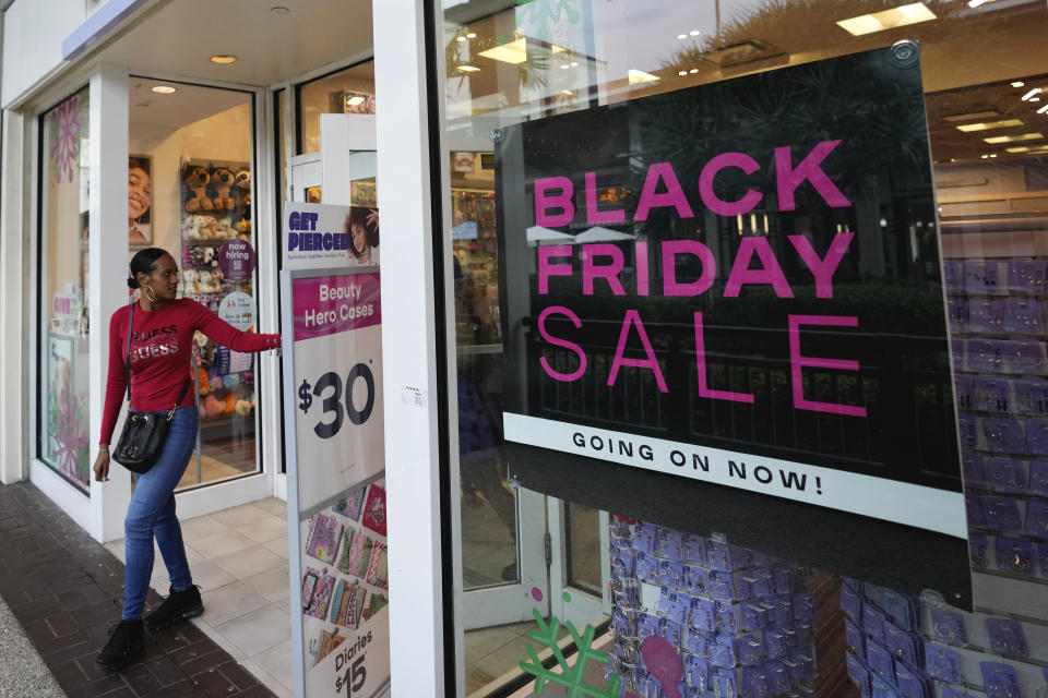 Shoppers exit a Claire's accessories store advertising sales ahead of Black Friday and the Thanksgiving holiday, Monday, Nov. 21, 2022, in Miami. Retailers are ushering in the start of the holiday shopping season on the day after Thanksgiving, preparing for the biggest crowds since 2019. (AP Photo/Rebecca Blackwell)