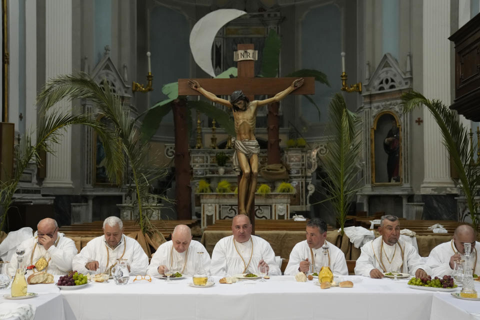 Members of a confraternity re-enact the Last Supper, bless loaves of bread in the Sant'Antonio Abate church during a Holy Thursday procession the in Procida Island, Italy, Thursday, March 28, 2024. Italy is known for the religious processions that take over towns big and small when Catholic feast days are celebrated throughout the year. But even in a country where public displays of popular piety are a centuries-old tradition, Procida's Holy Week commemorations stand out. (AP Photo/Alessandra Tarantino)