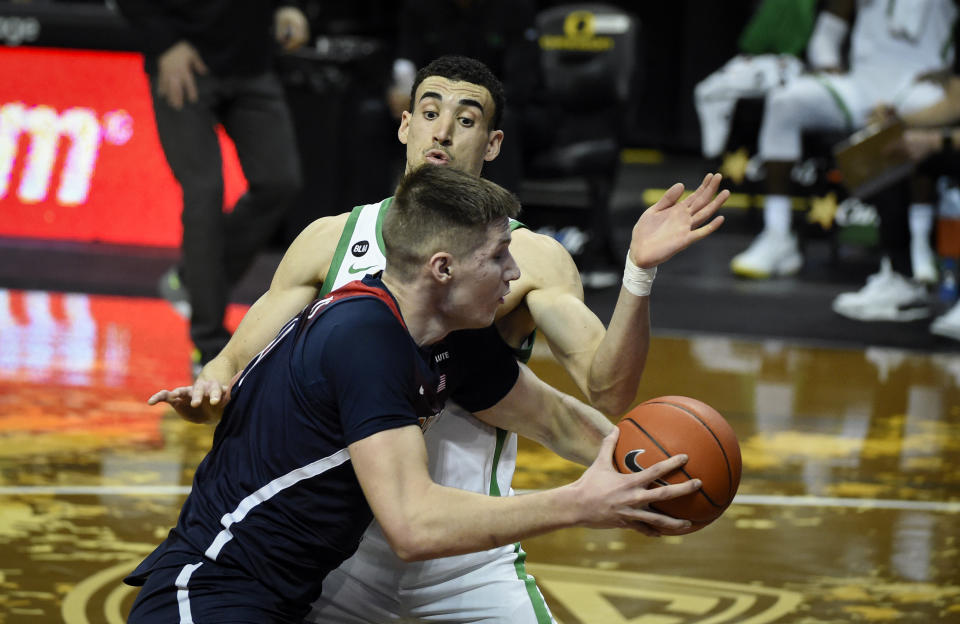 Arizona forward Azuolas Tubelis, front, is guarded by Oregon guard Chris Duarte (5) as he drives to the basket during the first half of an NCAA college basketball game Monday, March 1, 2021, in Eugene, Ore. (AP Photo/Andy Nelson)