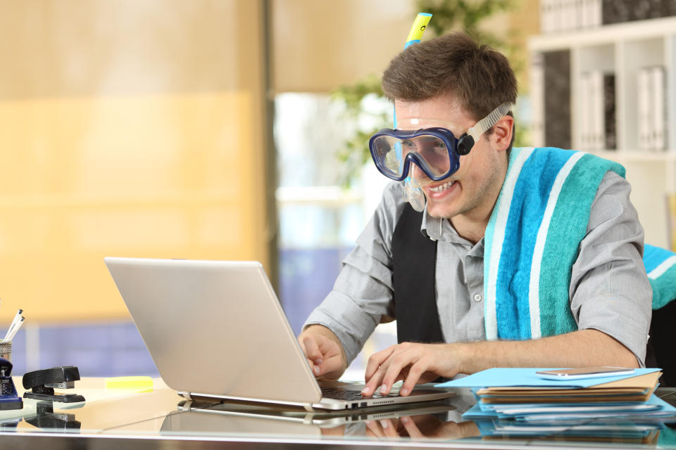 Pictured: Businessman checks email while wearing snorkel gear. Image: Getty