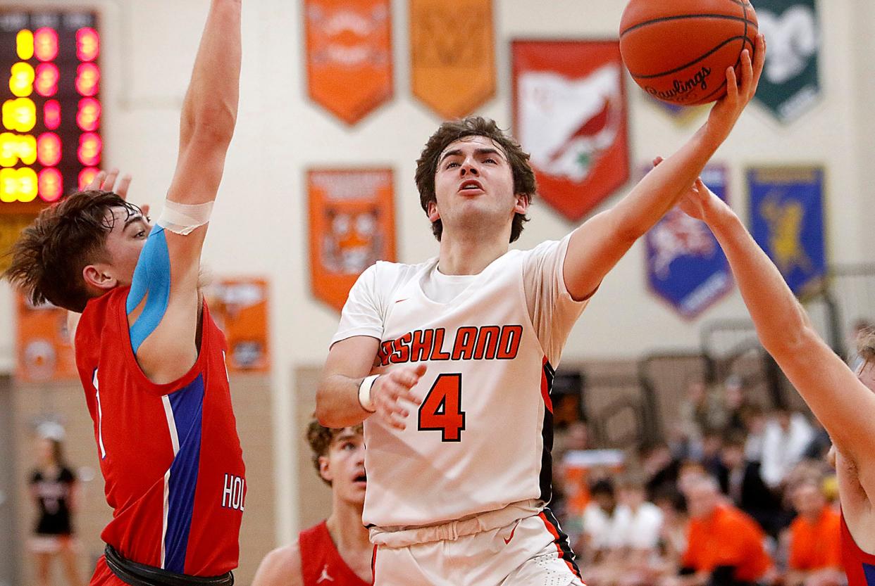 Ashland High School's Luke Denbow (4) drives in for a shot against West Holmes High School's Blake Morrison (1) during high school boys basketball action Tuesday, Dec. 28, 2021 at Arrow Arena. TOM E. PUSKAR/TIMES-GAZETTE.COM