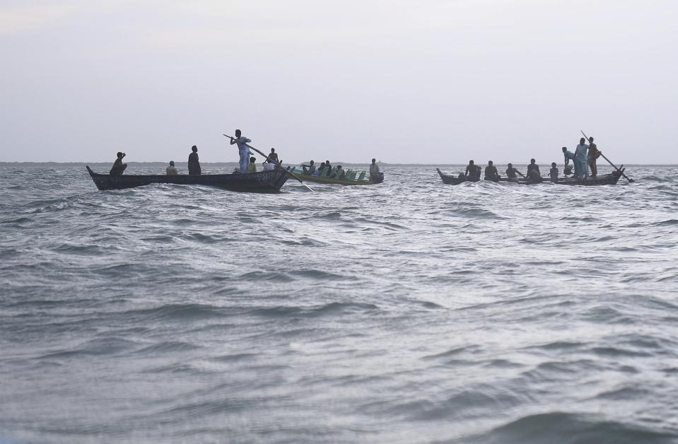 Rescue workers and volunteers search bodies following a boat capsized in Kenjhar Lake, some 122 kilometers (75 miles) east of Karachi, Pakistan, Monday, Aug. 17, 2020. A small boat carrying members from a Pakistani family capsized in Keenjhar Lake in southern Sindh province on Monday, leaving some people dead and few missing, police said. (AP Photo/Pervez Masih)