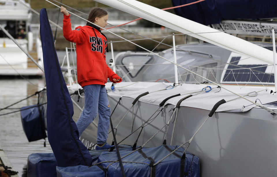 Greta Thunberg climbs onto the boat Malizia as it is moored in Plymouth, England Tuesday, Aug. 13, 2019. Greta Thunberg, the 16-year-old climate change activist who has inspired student protests around the world, is heading to the United States this week - in a sailboat. (AP Photo/Kirsty Wigglesworth)