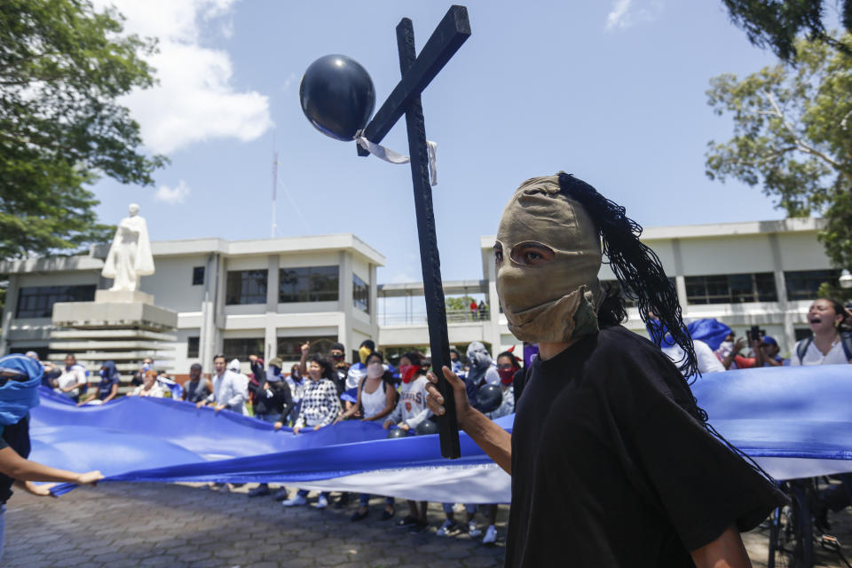 Students hiding their identify for fear of being identified and later attacked by security forces or government supporters protest inside the Central American University (UCA) to demand the release of all political prisoners, on the last day of a 90-day period for releasing such prisoners as part of negotiations between the government and opposition, in Managua, Nicaragua, Tuesday, June 18, 2019. Nicaragua's government said Tuesday that it has released all prisoners detained in relation to 2018 anti-government protests, though the opposition maintains that more than 80 people it considers political prisoners are still in custody. (AP Photo/Alfredo Zuniga)