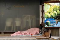 A homeless person sleeps near a closed coffee shop on the first day of the second national lockdown due to coronavirus disease (COVID-19) pandemic in Lisbon