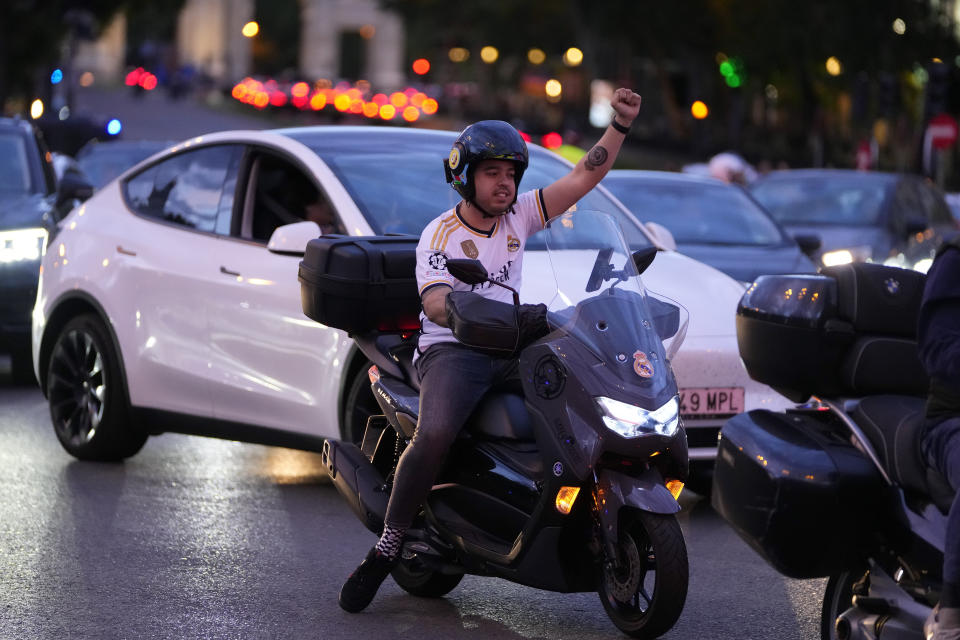 A Real Madrid supporter celebrates in Cibeles Square in Madrid after their team clinched the La Liga title, Saturday, May 4, 2024. Real, who had won earlier in the day, clinched the title after Barcelona failed to beat Girona. (AP Photo/Manu Fernandez)