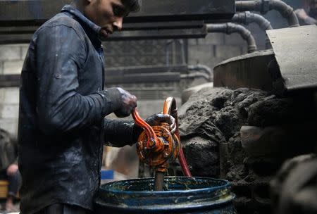 Khodor, 20, extracts fuel from plastic in a workshop in the rebel-held besieged Douma neighbourhood of Damascus, Syria April 2, 2017. REUTERS/Bassam Khabieh/Files