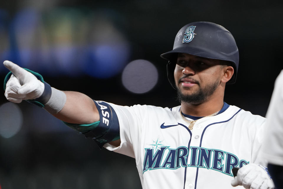 Seattle Mariners' Jonatan Clase points to the dugout after hitting an RBI single for his first major league hit against the Cincinnati Reds during the sixth inning of a baseball game Monday, April 15, 2024, in Seattle. (AP Photo/Lindsey Wasson)