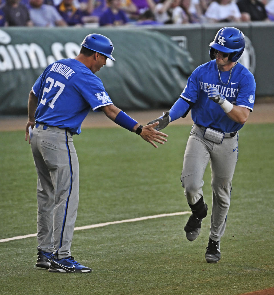 FILE - Kentucky coach Nick Mingione greets Chase Stanke (9) at third base after Stanke hit a two-run home run against LSU during an NCAA college baseball game Friday, April 14, 2023, in Baton Rouge, La. (Hilary Scheinuk/The Advocate via AP)/The Advocate via AP)