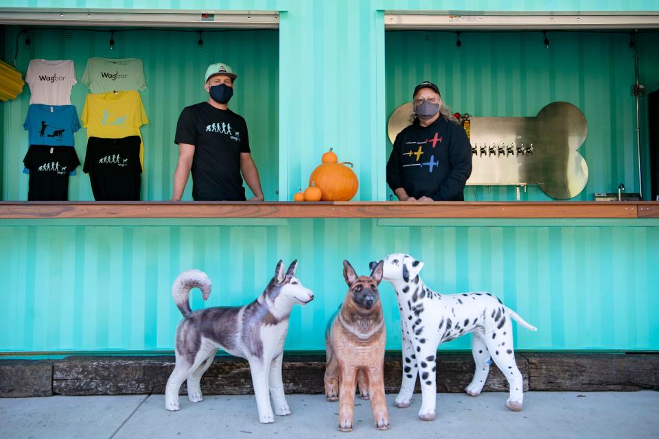 Wagbar owner and creator Kendal Kulp stands behind the bar, made from a shipping container, with his operations manager, and father, Kajur, at the hybrid dog park and bar in Weaverville on Oct. 7, 2020.