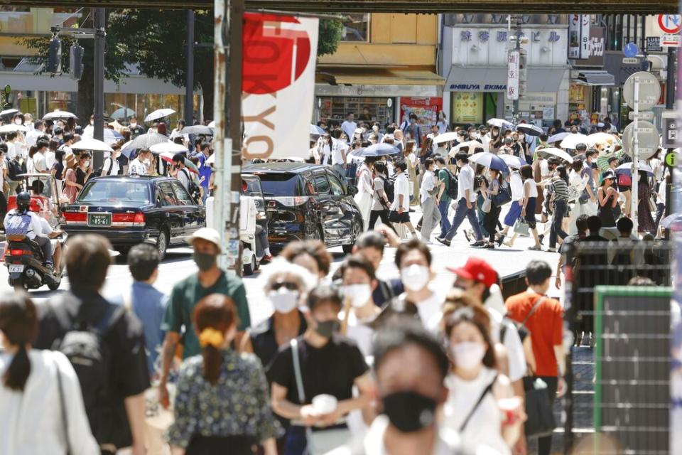 People wearing masks amid the novel coronavirus pandemic walk in Tokyo's Shibuya district on July 22, 2021, a day before the opening ceremony of the Tokyo Olympics.<span class="copyright">Kyodo News/AP Images</span>