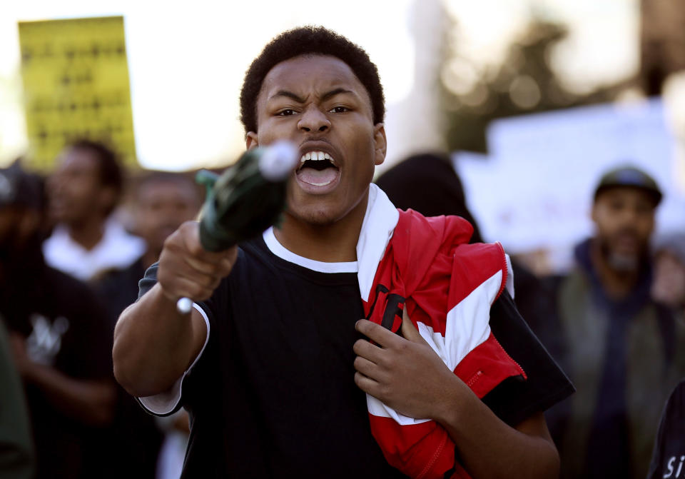 A&nbsp;protester carries an umbrella as he marches during a protest of the police shooting of Stephon Clark.