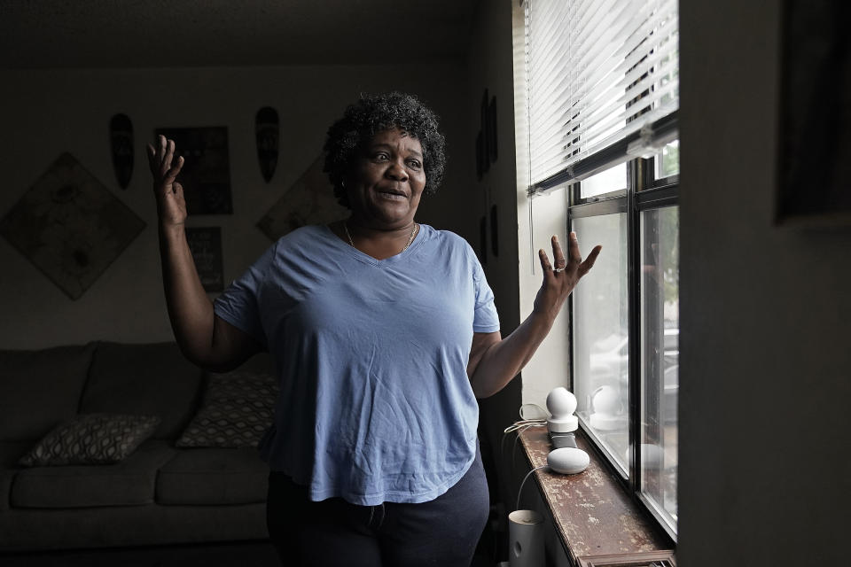 Bobbie Boyd stands near the window air conditioner which is the only unit in her two-bedroom apartment Wednesday, Aug. 9, 2023, in Fayetteville, Ark. On a fixed income, Boyd sacrifices meals, health care, and car insurance among other necessities to pay rent and keep cool in the midst of this summer's prolonged heat waves. (AP Photo/Charlie Riedel)