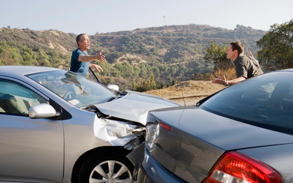 Two men arguing about damaged cars