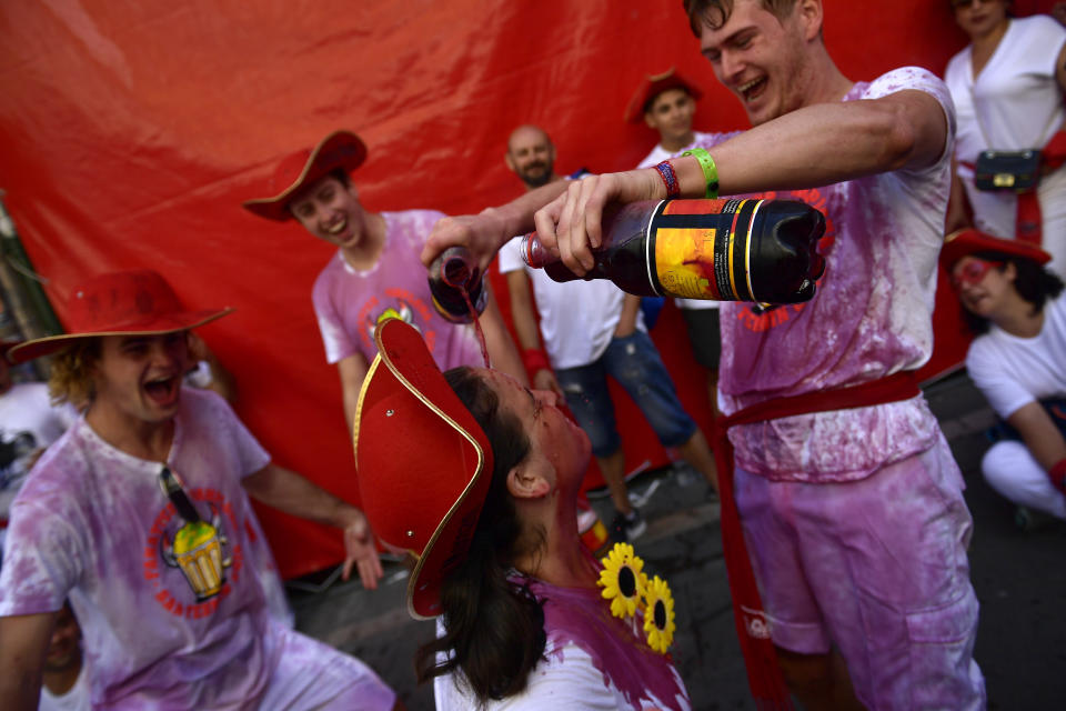 A man pours wine on a woman as they start celebrating early while waiting for the launch of the 'Chupinazo' rocket, to celebrate the official opening of the 2019 San Fermin fiestas with daily bull runs, bullfights, music and dancing in Pamplona, Spain, July 6, 2019. (Photo: Alvaro Barrientos/AP)