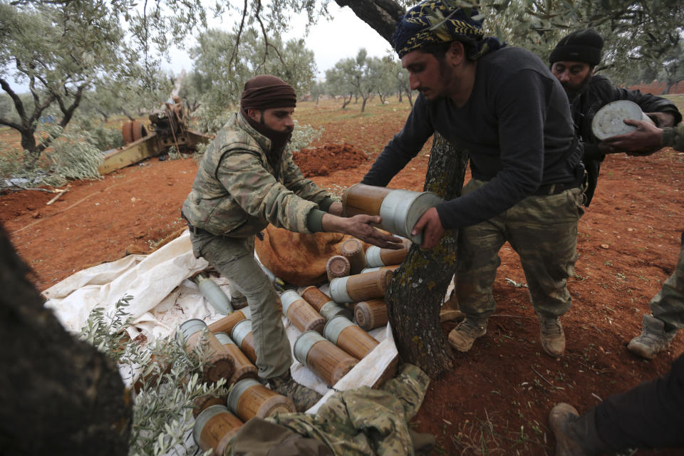 Syrian rebel fighters prepare to shoot a howitzer toward the government positions near the village of Nerab, in Idlib province, Thursday, Feb. 6, 2020. Turkey sent more reinforcements into northwestern Syria on Thursday, setting up new positions in an attempt to stop a Syrian government offensive on the last rebel stronghold in the war-torn country, state media and opposition activists said. (AP Photo/Ghaith Alsayed)