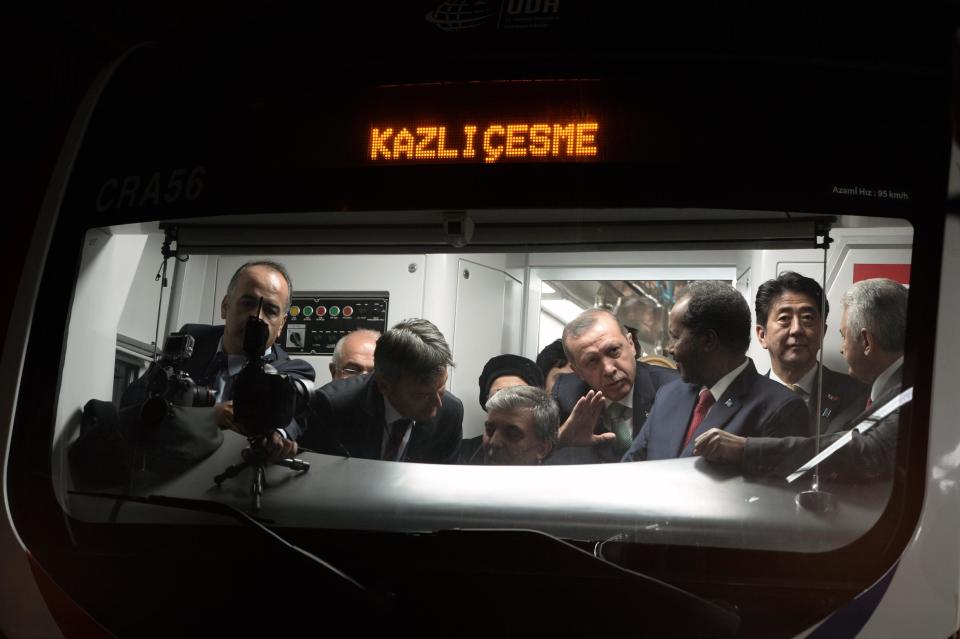 Japanese Prime Minister Shinzo Abe, second right, his Turkish counterpart Recep Tayyip Erdogan, fourth right, and other officials wait inside a train to cross the Bosporus after the inauguration of the tunnel called the Marmaray in Istanbul, Turkey, Tuesday, Oct. 29, 2013. Turkey is for the first time connecting its European and Asian sides with a railway tunnel set to open Tuesday, completing a plan initially proposed by an Ottoman sultan about 150 years ago. The Marmaray, is among a number of large infrastructure projects under the government of Prime Minister Recep Tayyip Erdogan that have helped boost the economy but also have provoked a backlash of public protest.(AP Photo)