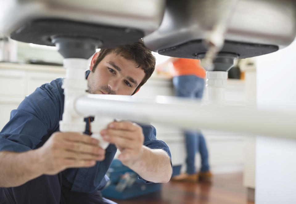 a plumber working in a kitchen