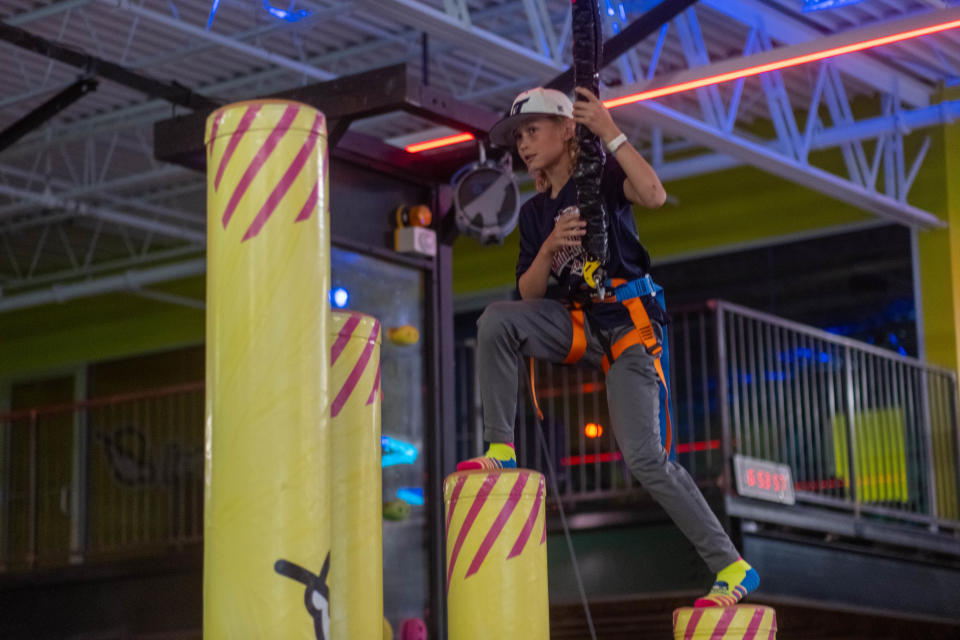 A young boy climbs higher over obstacles at Urban Air Adventure Park in Amarillo.