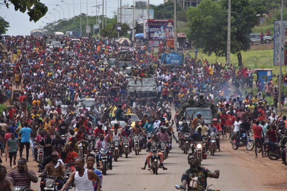 Seen here, People celebrate in the streets with members of Guinea's armed forces after the arrest of the country's president.