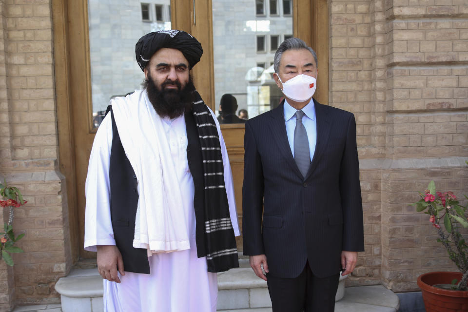 In this photo released by Xinhua News Agency, Chinese Foreign Minister Wang Yi, right, poses for photos with Amir Khan Muttaqi, acting foreign minister of the Afghan Taliban's caretaker government, in Kabul, Afghanistan on March 24, 2022. Chinese leader Xi Jinping on Thursday, March 31, 2022 issued strong backing for Afghanistan at a regional conference, while making no mention of human rights abuses by the country's Taliban leaders. (Saifurahman Safi/Xinhua via AP)