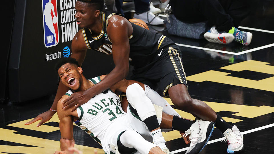 Giannis Antetokounmpo cried out in pain after hyper-extending his knee in a collision Atlanta's Clint Capela.