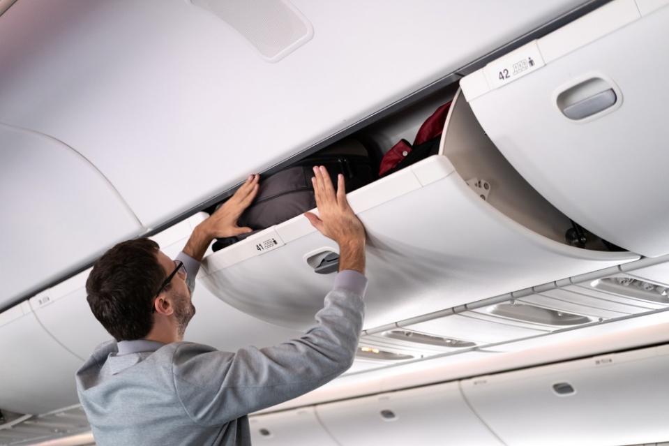 Placing your bag in the overhead bin in such a way that makes room for other passengers’ luggage is what Armstrong considers a “little considerate act.” Space_Cat – stock.adobe.com