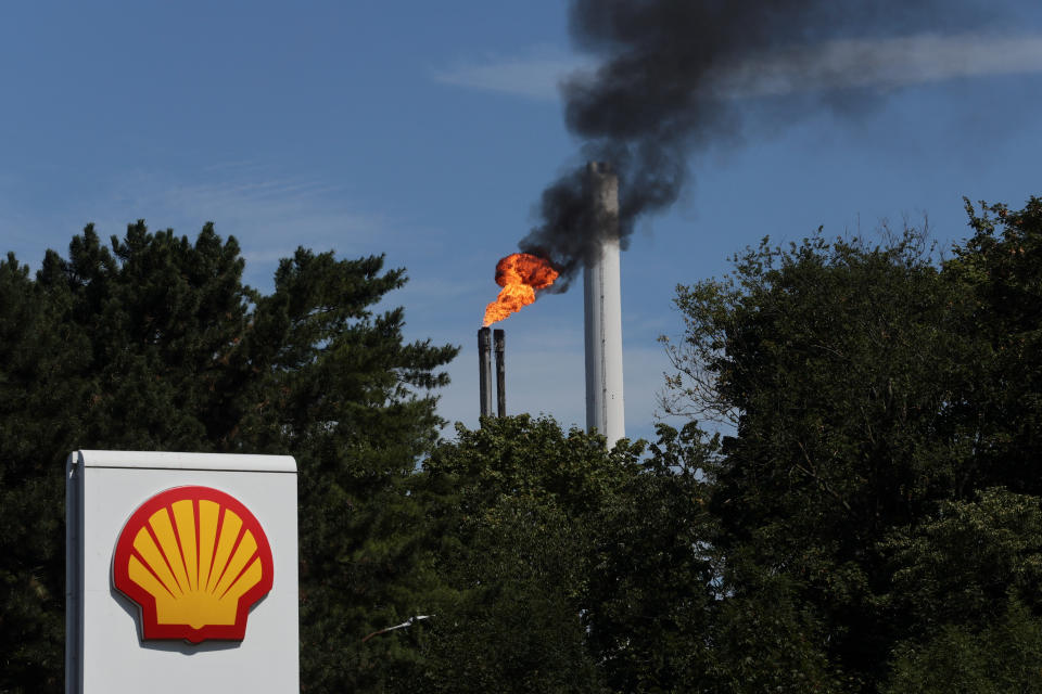 The sign of a Shell petrol station is seen in front of a burning pilot flame atop a flare stack at the refinery of the Shell Energy and Chemicals Park Rheinland in Godorf near Cologne, Germany, August 3, 2022.  REUTERS/Wolfgang Rattay