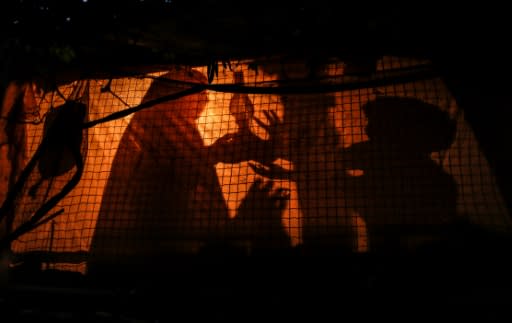 A Palestinian woman uses a gas lamp during a power cut in an impoverished area of the Khan Yunis refugee camp in southern Gaza on July 29, 2018