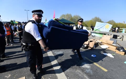 Police officers remove items used by Extinction Rebellion protesters from Waterloo Bridge - Credit: Paul Grover for the Telegraph