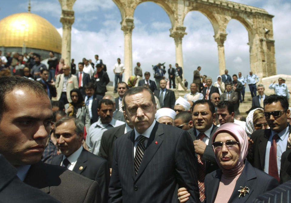 FILE- Turkish Prime Minister Recep Tayyip Erdogan, center, and his wife Emine, right, guarded by scores of Israeli and Palestinian security officials, as they visit the al-Aqsa mosque compound, known by Jews as Temple Mount, in Jerusalem's Old City, on May 2, 2005. (AP Photo/Muhammed Muheisen, File)