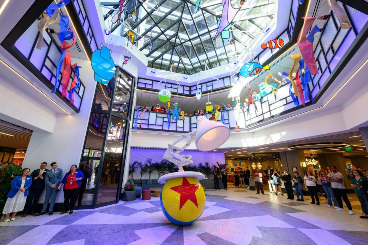 a sculpture of the iconic pixar ball and lamp welcomes guests at the front lobby entrance of pixar place hotel at disneyland resort in anaheim, calif, with an abstract mobile of pixar characters floating from the skylight above richard harbaughdisneyland resort 