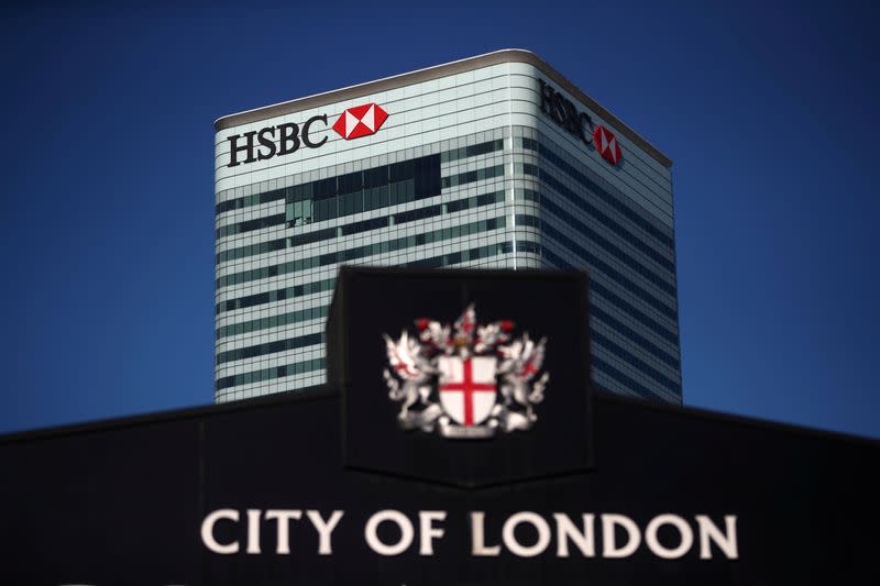 FILE PHOTO: HSBC's building in Canary Wharf is seen behind a City of London sign outside Billingsgate Market in London