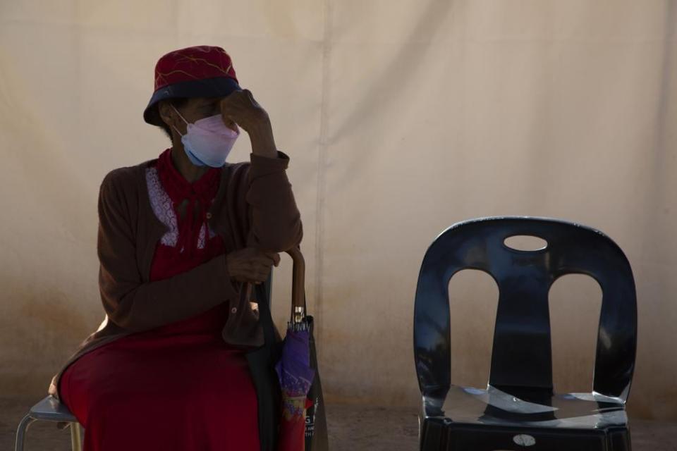 A woman waits in a queue to be screened for COVID-19 at a testing centre in Soweto, South Africa, Wednesday, May 11, 2022. (AP Photo/Denis Farrell)