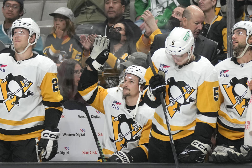 Pittsburgh Penguins defenseman Erik Karlsson, center, waves after a video of his time with the San Jose Sharks was played during the first period of an NHL hockey game against the Sharks in San Jose, Calif., Saturday, Nov. 4, 2023. (AP Photo/Jeff Chiu)