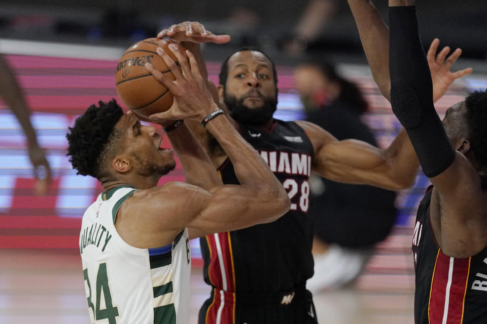 Milwaukee Bucks' Giannis Antetokounmpo (34) goes to the basket defended by Miami Heat's Andre Iguodala (28) in the second half of an NBA conference semifinal playoff basketball game Friday, Sept. 4, 2020, in Lake Buena Vista, Fla. (AP Photo/Mark J. Terrill)
