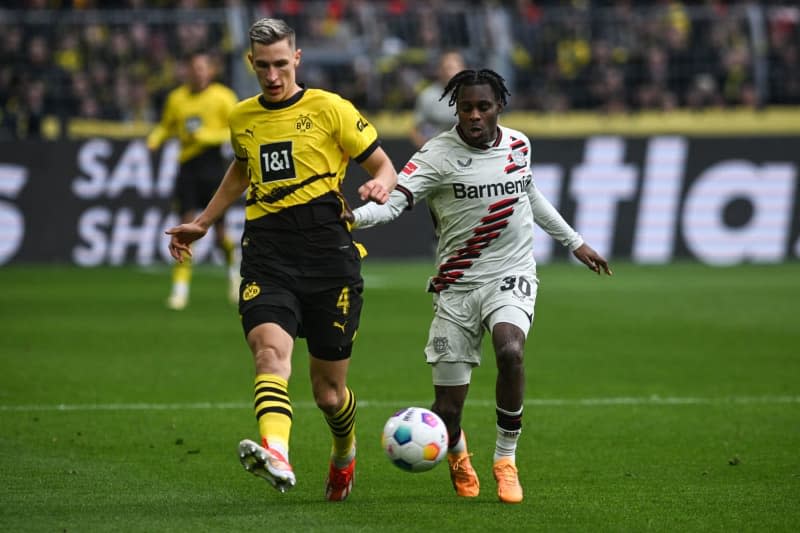 Dortmund's Nico Schlotterbeck and Leverkusen's Jeremie Frimpong battle for the ball during the German Bundesliga soccer match between Borussia Dortmund and Bayer Leverkusen at Signal Iduna Park. Bernd Thissen/dpa