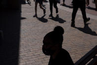 A shopper wearing a face mask sits in the shade at the Citadel Outlets in Commerce, Calif., Thursday, July 2, 2020. California Gov. Gavin Newsom on Thursday urged Californians to turn to their "better angels" and use common sense over the holiday weekend by wearing a mask and skipping traditional gatherings with family and friends. (AP Photo/Jae C. Hong)