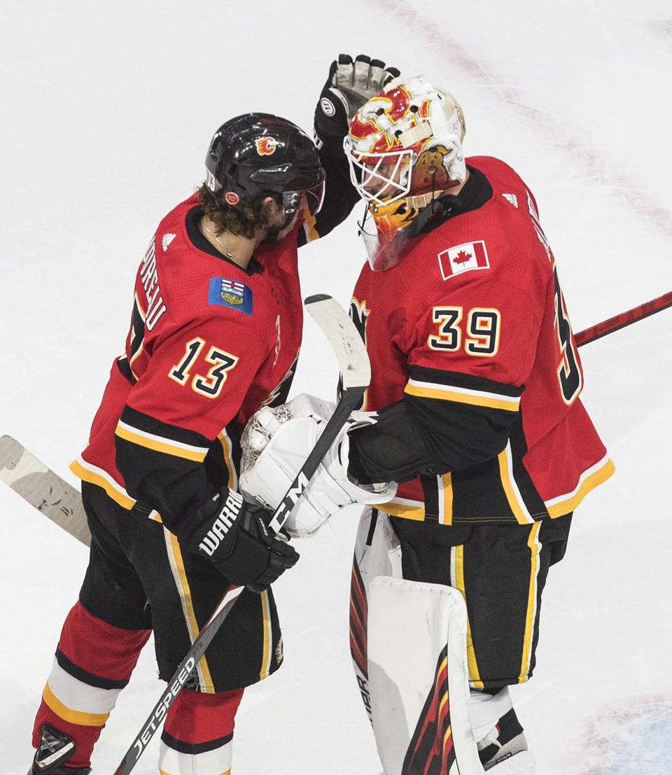 Calgary Flames' Johnny Gaudreau (13) and goalie Cam Talbot (39) celebrate the win over the Dallas Stars during the first round of an NHL Stanley Cup playoff hockey series, Friday, Aug. 14, 2020, in Edmonton, Alberta. (Jason Franson/The Canadian Press via AP)