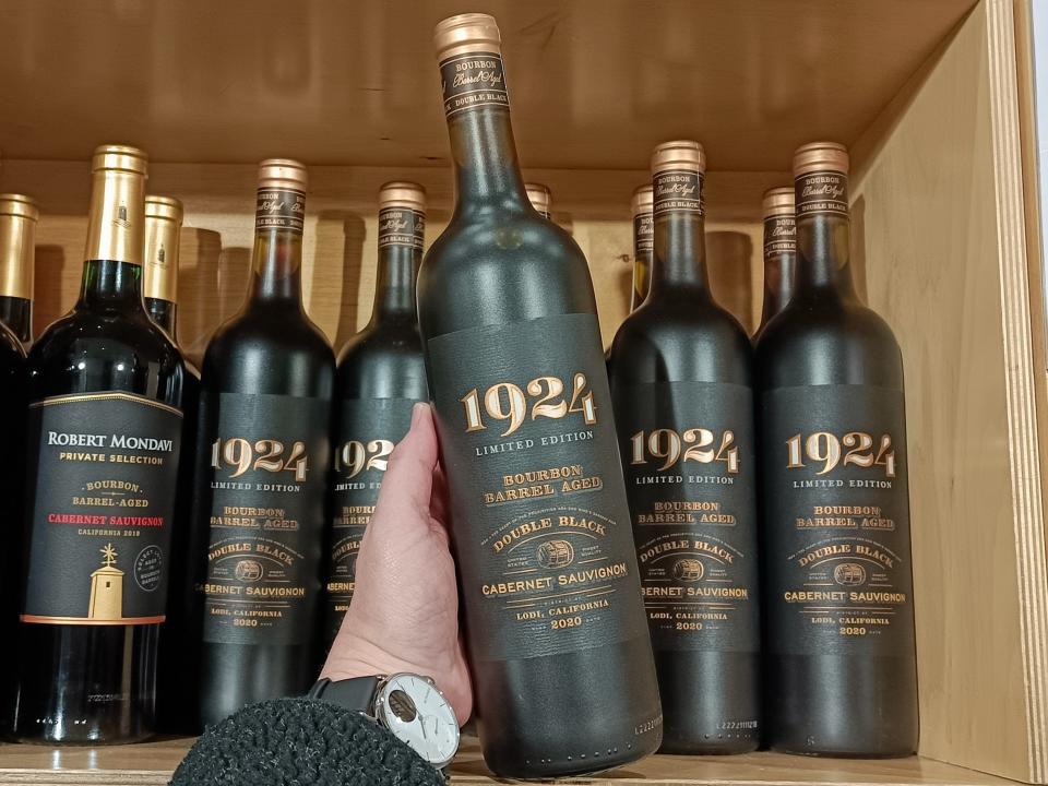 black and gold bottles of 1924 cabernet Sauvignon in wooden shelf at Costco