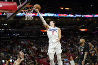 Los Angeles Clippers guard Luke Kennard (5) goes to the basket over Miami Heat guard Duncan Robinson, left, and forward P.J. Tucker (17) during the second half of an NBA basketball game, Friday, Jan. 28, 2022, in Miami. (AP Photo/Lynne Sladky)