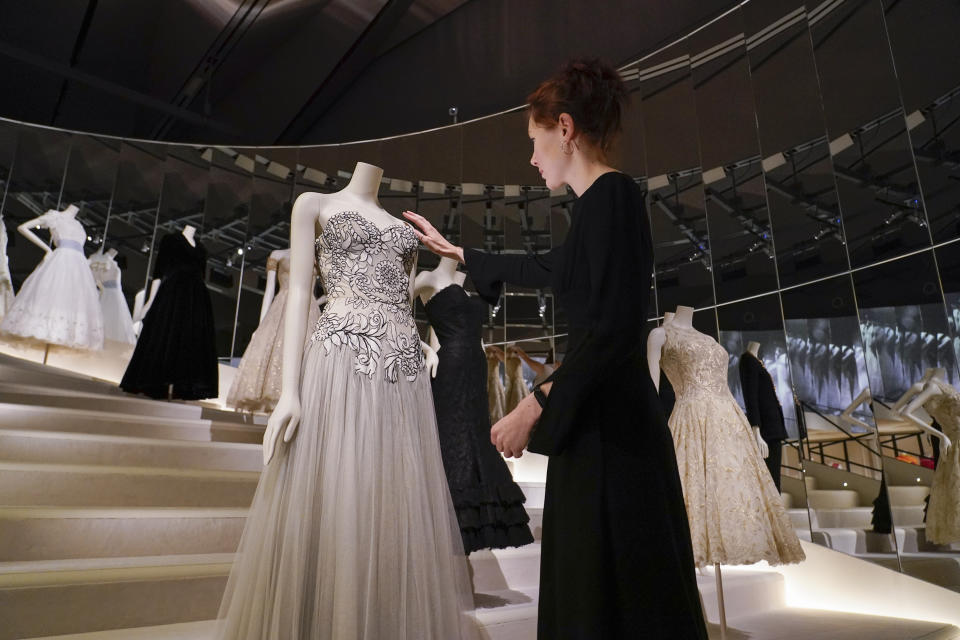 A curator adjusts a creation which is displayed as part of the "Gabrielle Chanel. Fashion Manifesto" exhibition at the Victoria and Albert museum, in London, Tuesday, Sept. 12, 2023.(AP Photo/Alberto Pezzali)