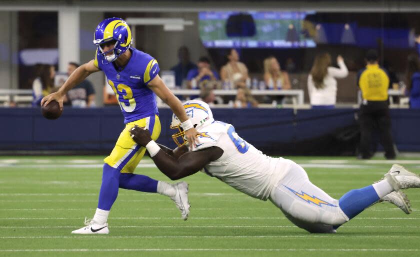 INGLEWOOD, CA - AUGUST 12: Rams quarterback Stetson Bennett gets sacked by Chargers defensive lineman CJ Okoye for a 16-yard loss in the fourth quarter during the Rams and Chargers preseason game at SoFi Stadium in Inglewood, CA on Saturday, Aug. 12, 2023. (Myung J. Chun / Los Angeles Times)