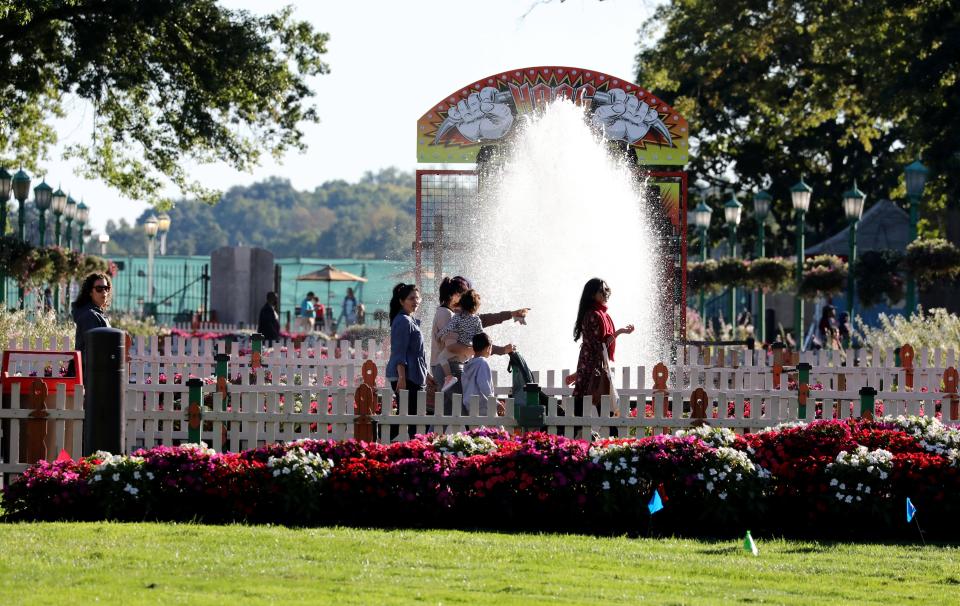 Park goers pass a water feature near the beautiful lawn and landscape at Playland Amusement Park in Rye, on the last weekend of the season, Sept. 24, 2022. 