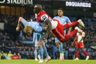 Manchester City's Kevin De Bruyne, left, and Wycombe Wanderers Adebayo Akinfenwa collide as they compete for the ball during the English League Cup third round soccer match between Manchester City and Wycombe Wanderers at Etihad Stadium, in Manchester England, Tuesday, Sept. 21, 2021. (AP Photo/Dave Thompson)